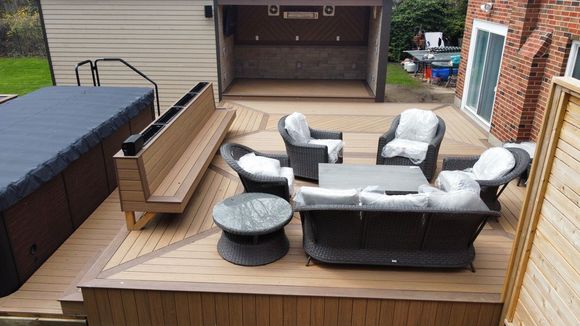 Patterned Timbertech composite deck, bench with built in, Outdoor kitchen area, with herringbone feature wall and storage shed.