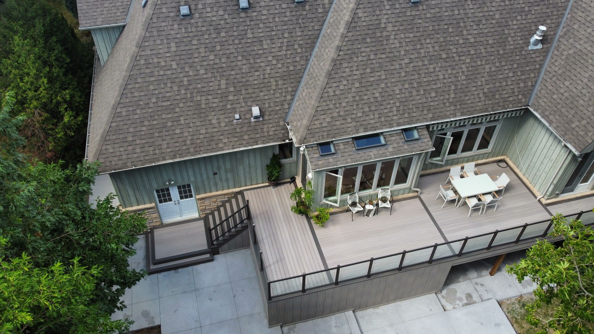 An aerial view of a large house with a large deck.