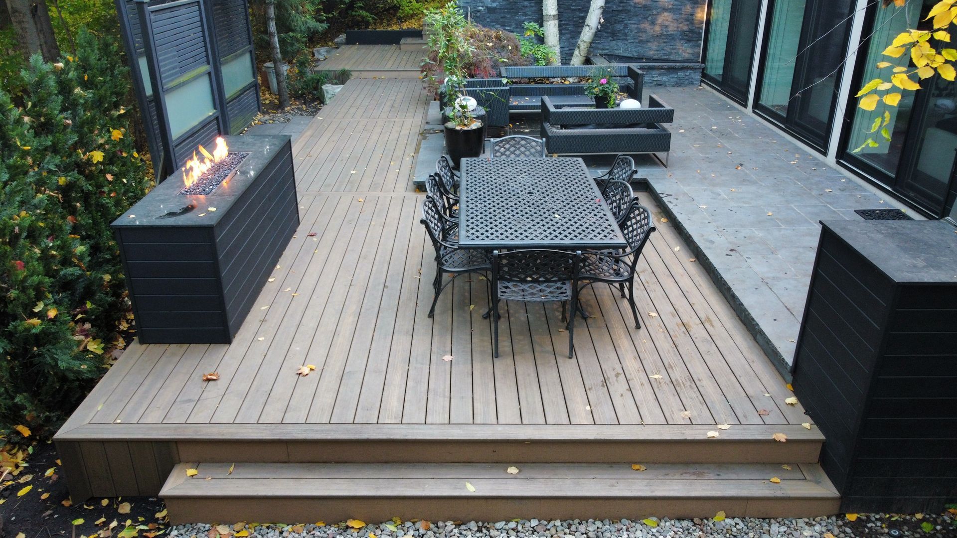 A wooden deck with a table and chairs and a fire pit