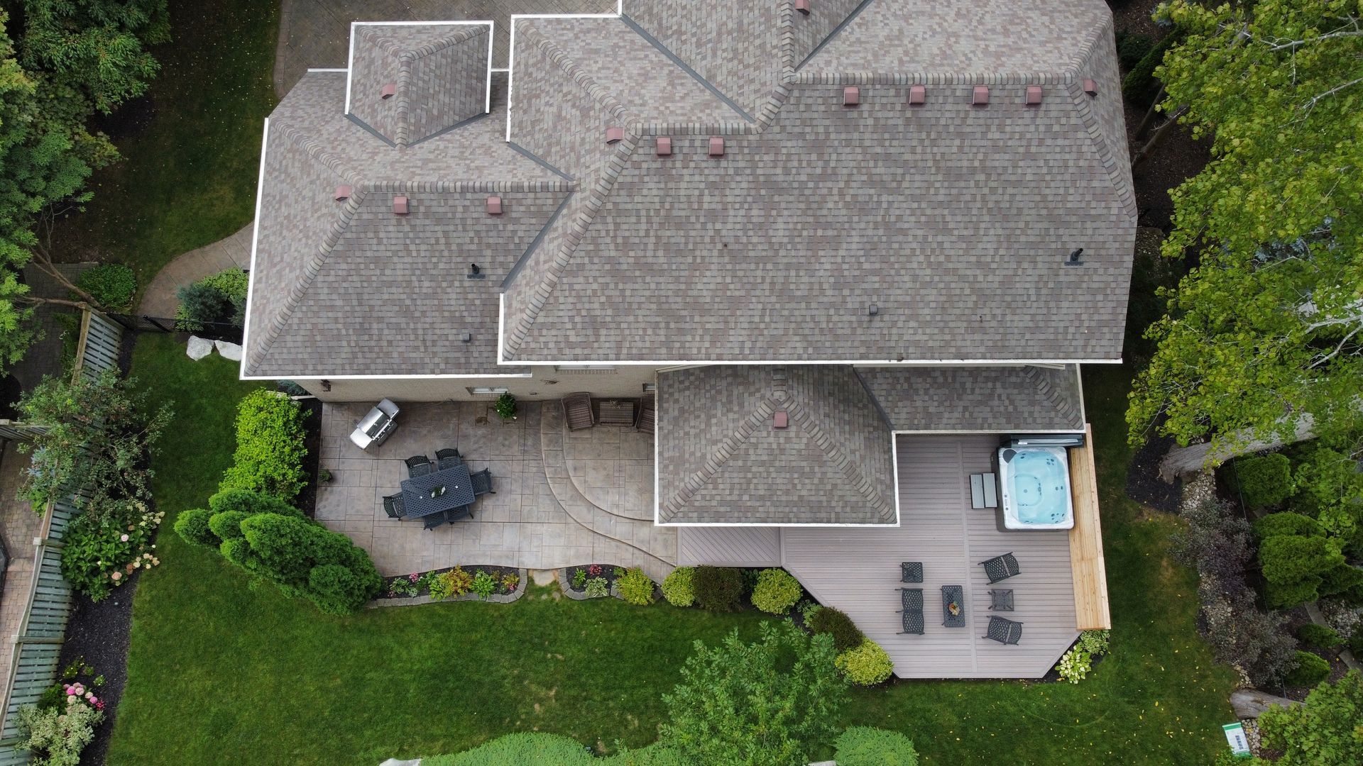 An aerial view of a large house with a hot tub in the backyard.