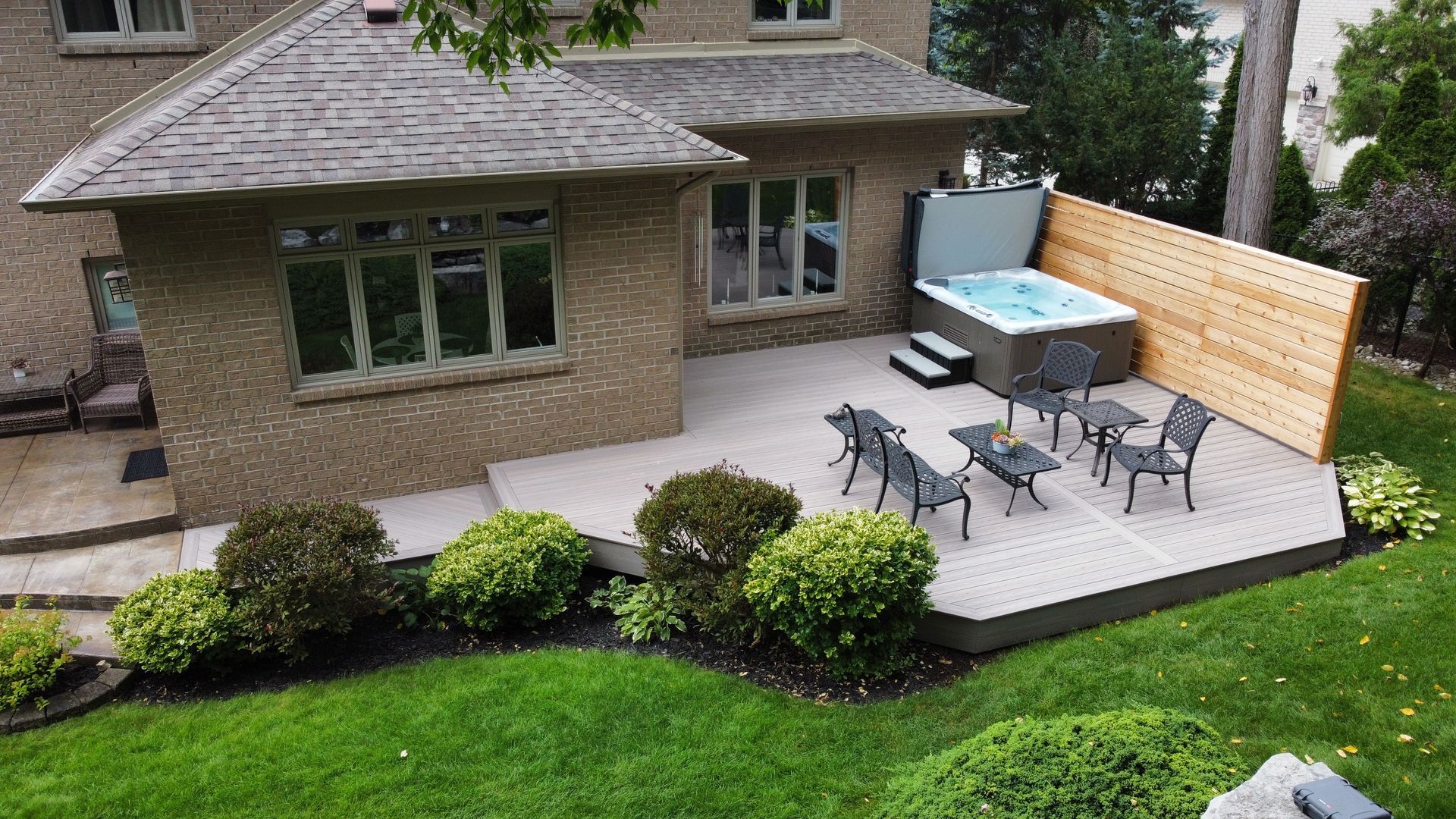 A house with a patio and a hot tub in the backyard.