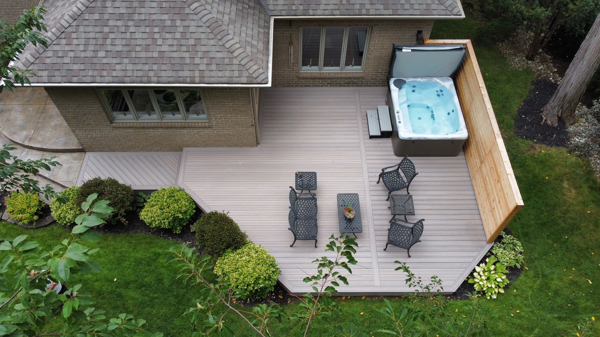 An aerial view of a house with a hot tub on the deck.