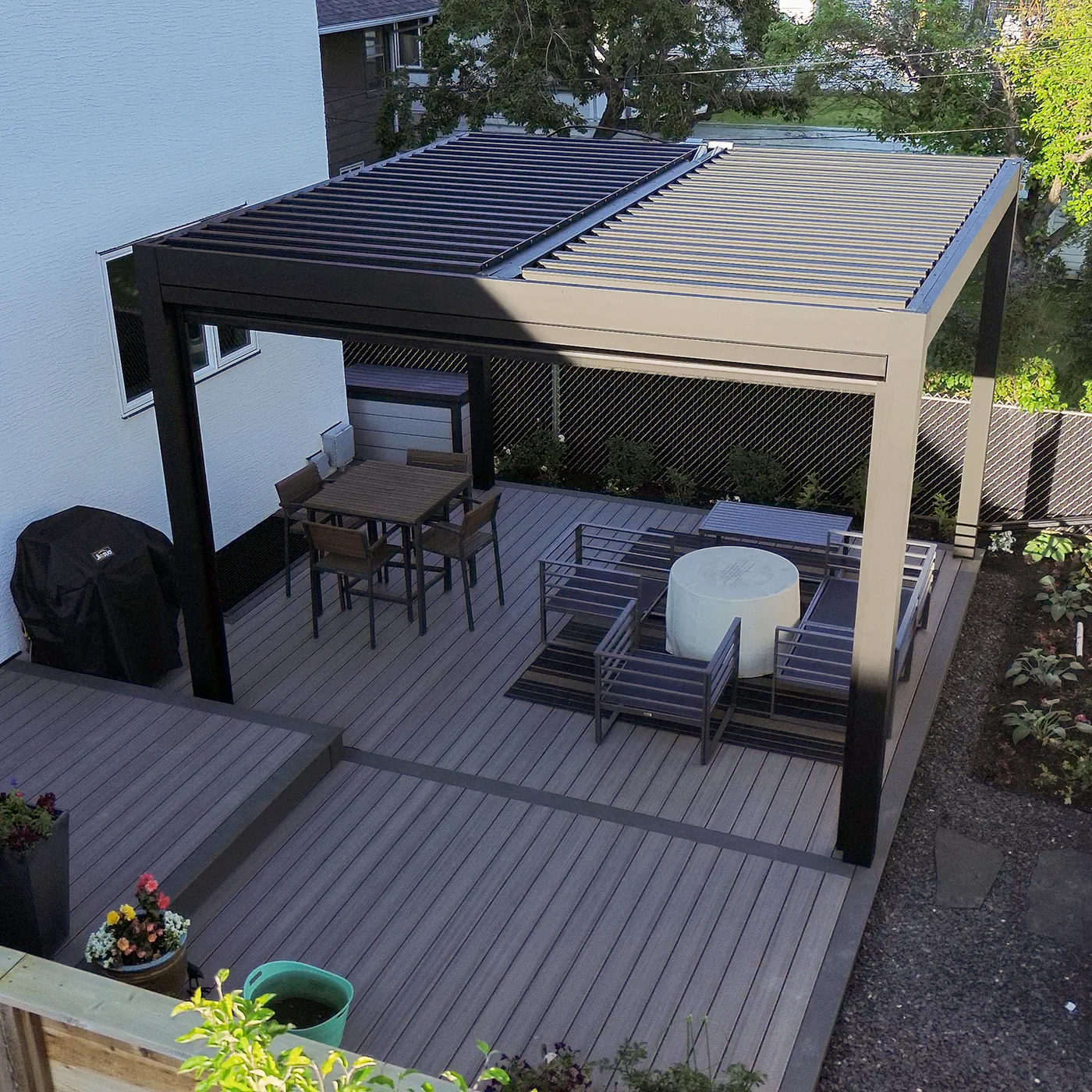 An aerial view of a deck with tables and chairs under a pergola