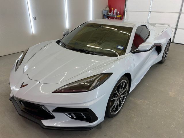 A white sports car is parked in a garage.