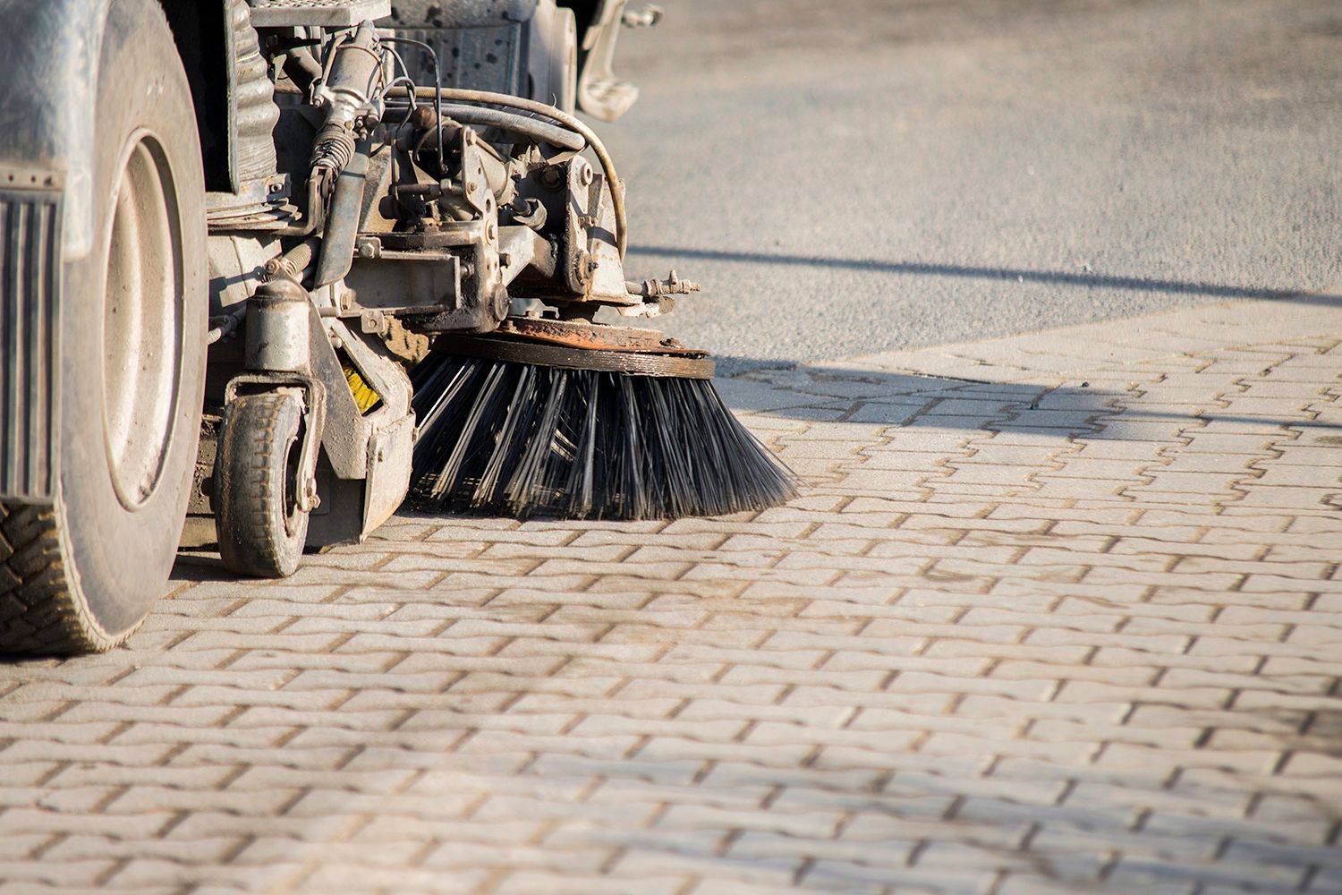 Street sweeper's brush sweeping a paved surface, detail shot. Street sweeper's brush sweeping a paved surface, detail shot.
