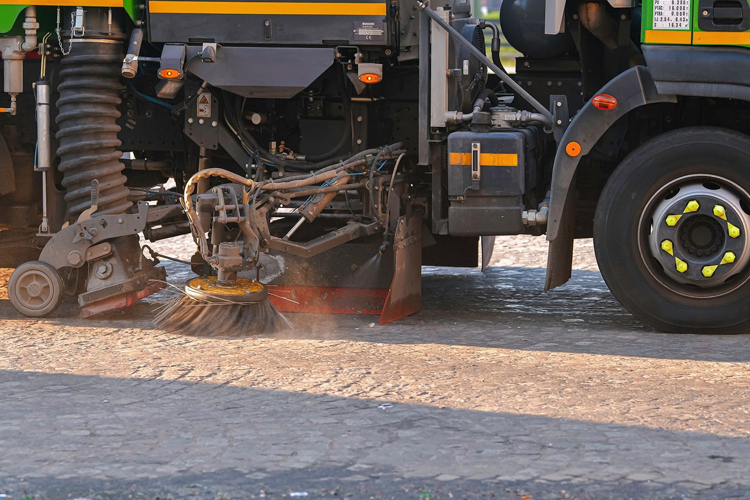 Street sweeper with brushes and water spraying on a road. Street sweeper with brushes and water spraying on a road.