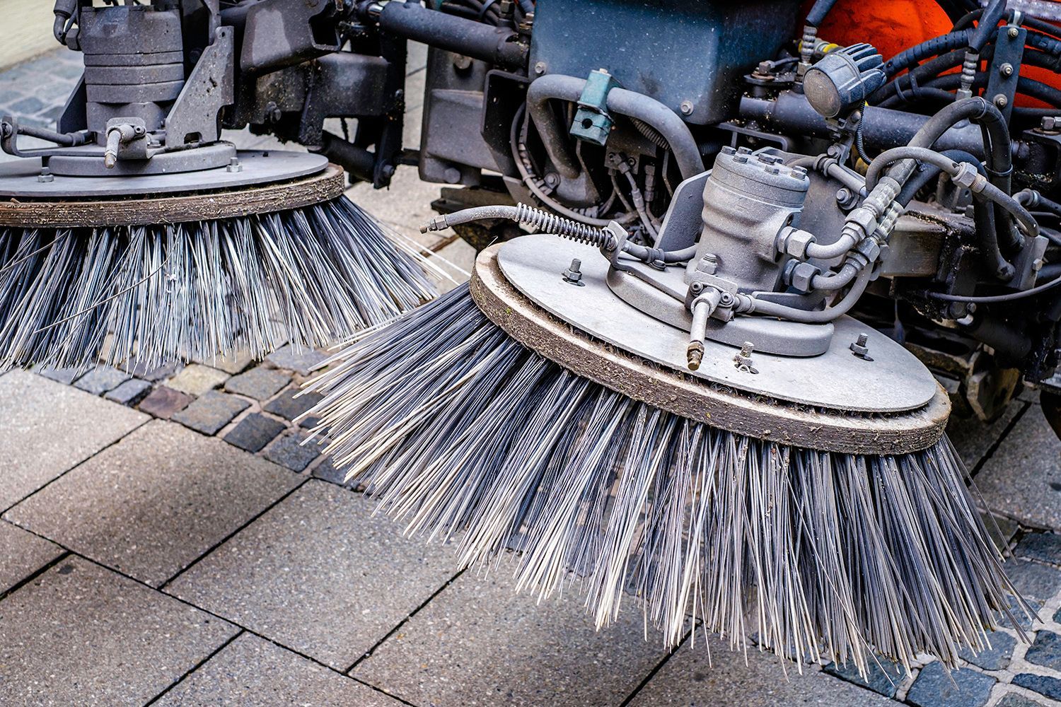 Street sweeper's rotating brushes cleaning a brick sidewalk. Street sweeper's rotating brushes cleaning a brick sidewalk.
