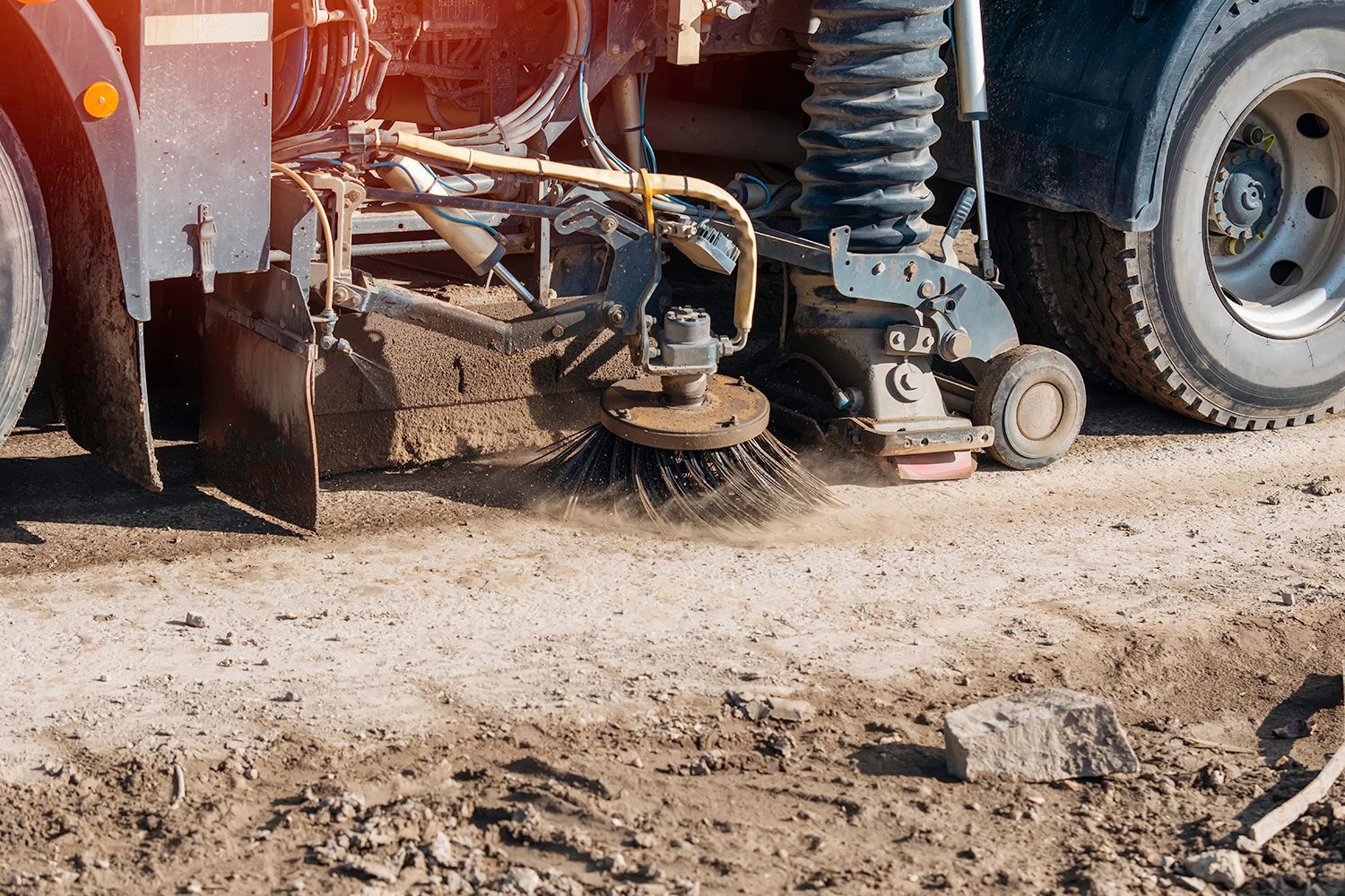 Street sweeper truck cleaning a dirt road. Street sweeper truck cleaning a dirt road.
