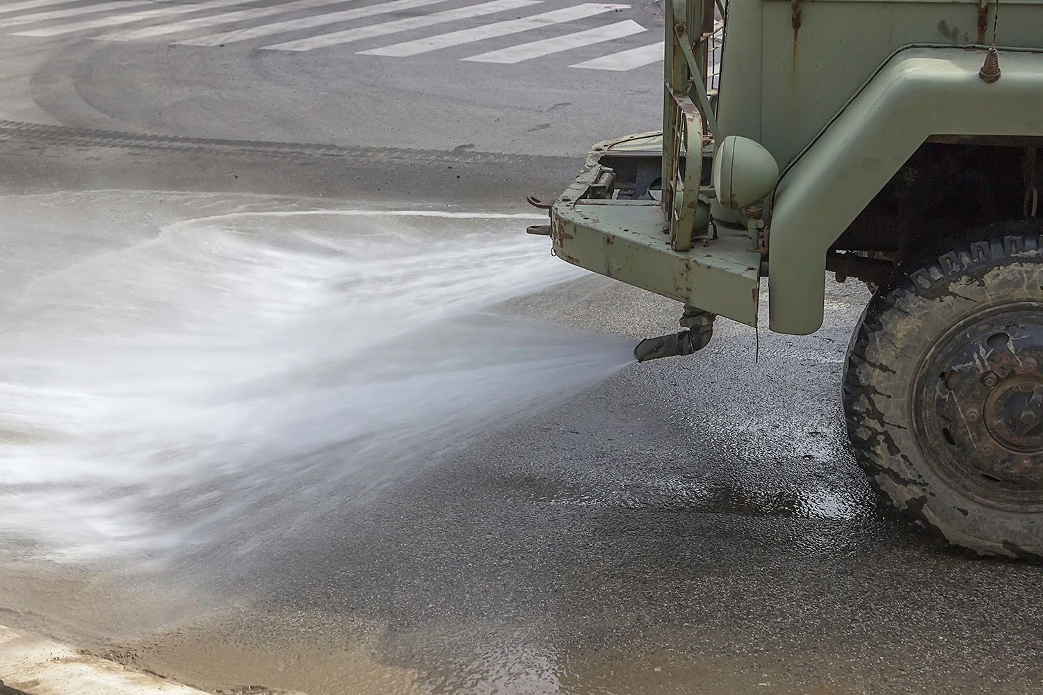 A truck sprays water on a road.