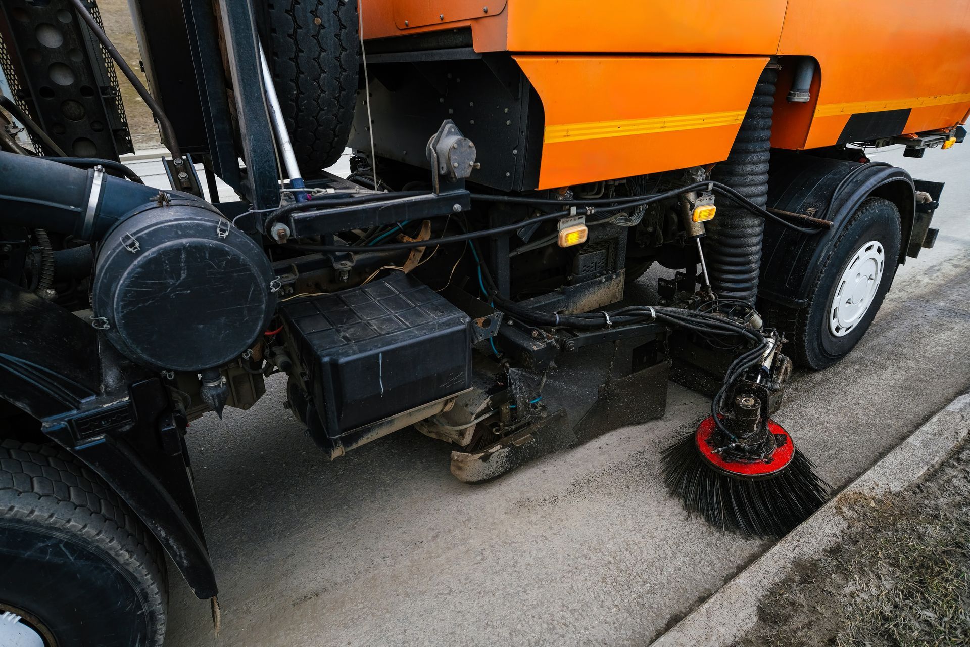 A tractor spraying water onto asphalt, possibly for cleaning or marking a road. A tractor spraying water onto asphalt, possibly for cleaning or marking a road.