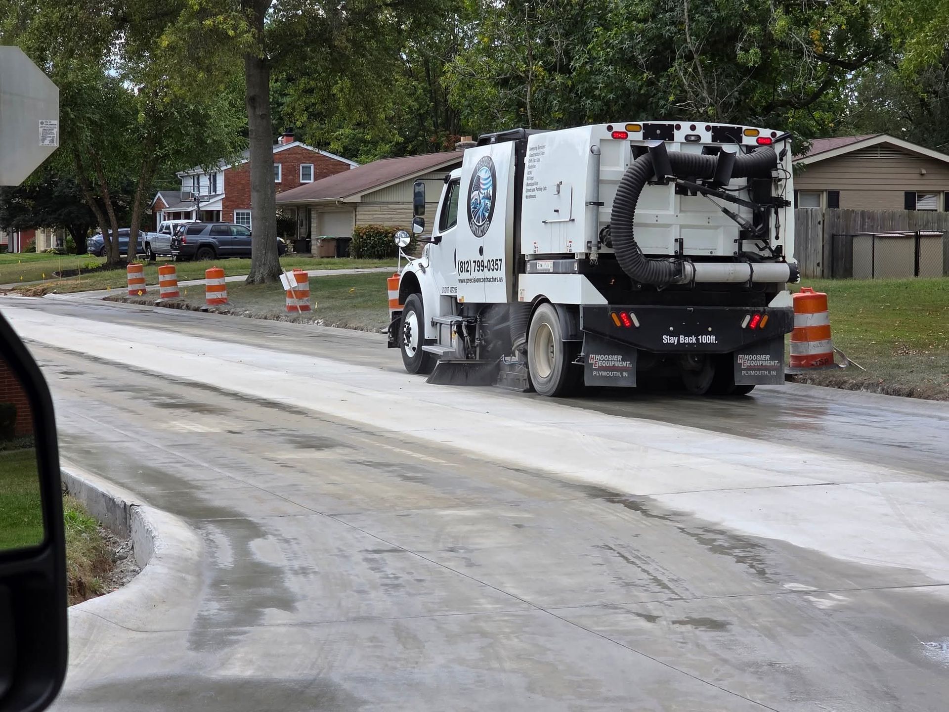A tractor spraying water onto asphalt, possibly for cleaning or marking a road. A tractor spraying water onto asphalt, possibly for cleaning or marking a road.
