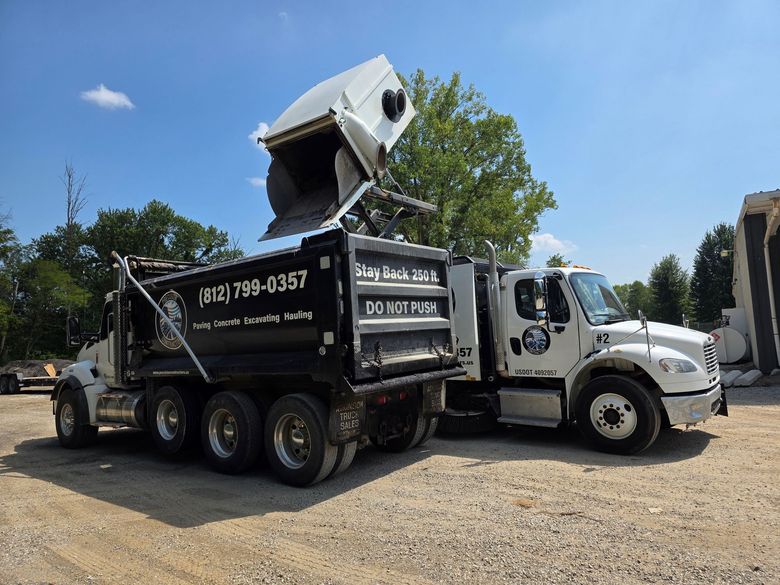 Street sweepers with rotating yellow brushes cleaning a road.