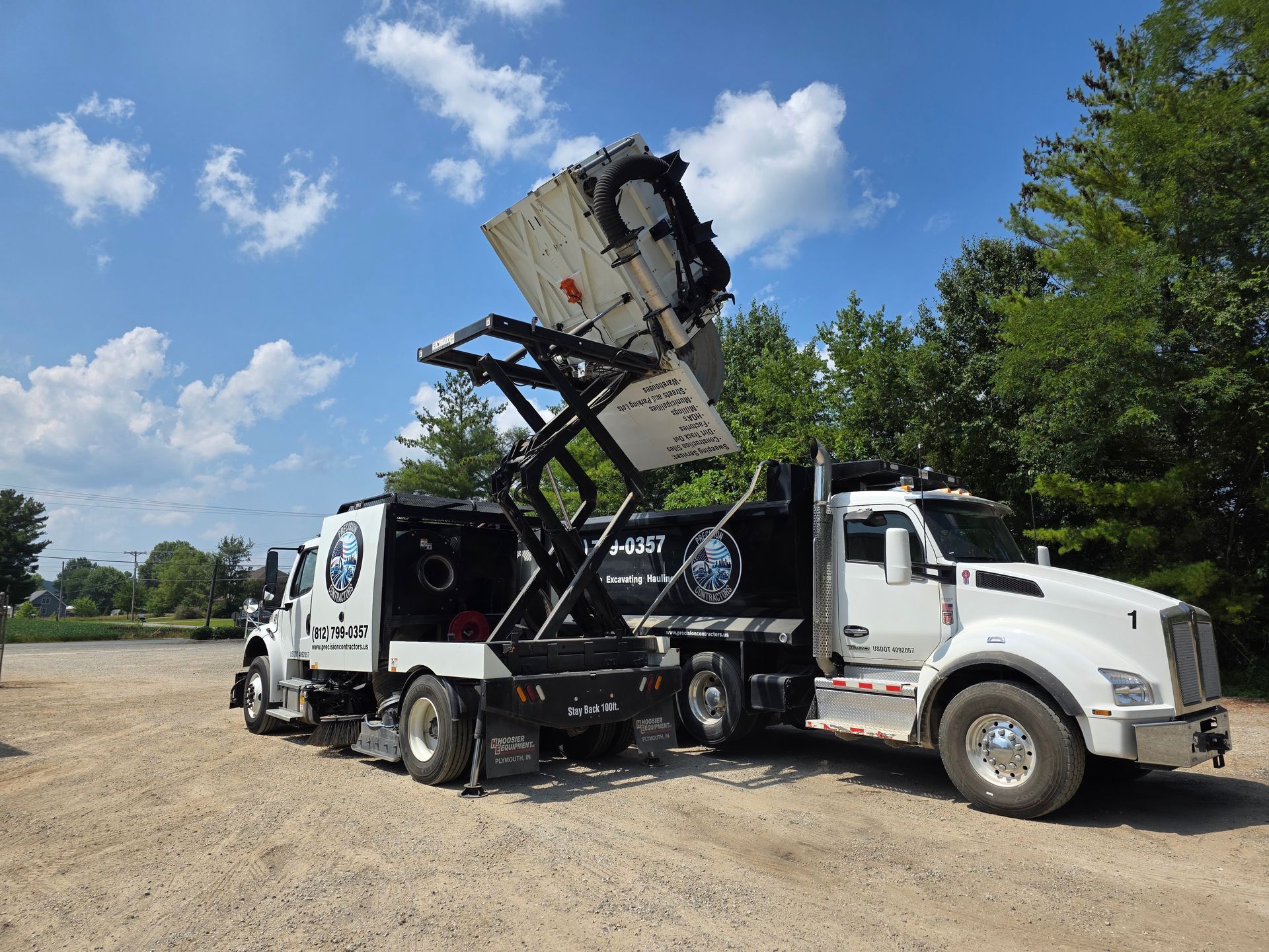 Skid steer loader with a sweeper attachment on a road under a bridge. Skid steer loader with a sweeper attachment on a road under a bridge.