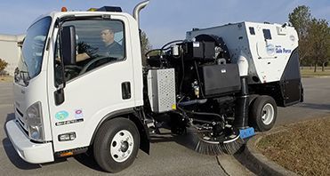 Street sweeper brush cleaning a dusty road surface. Street sweeper brush cleaning a dusty road surface.