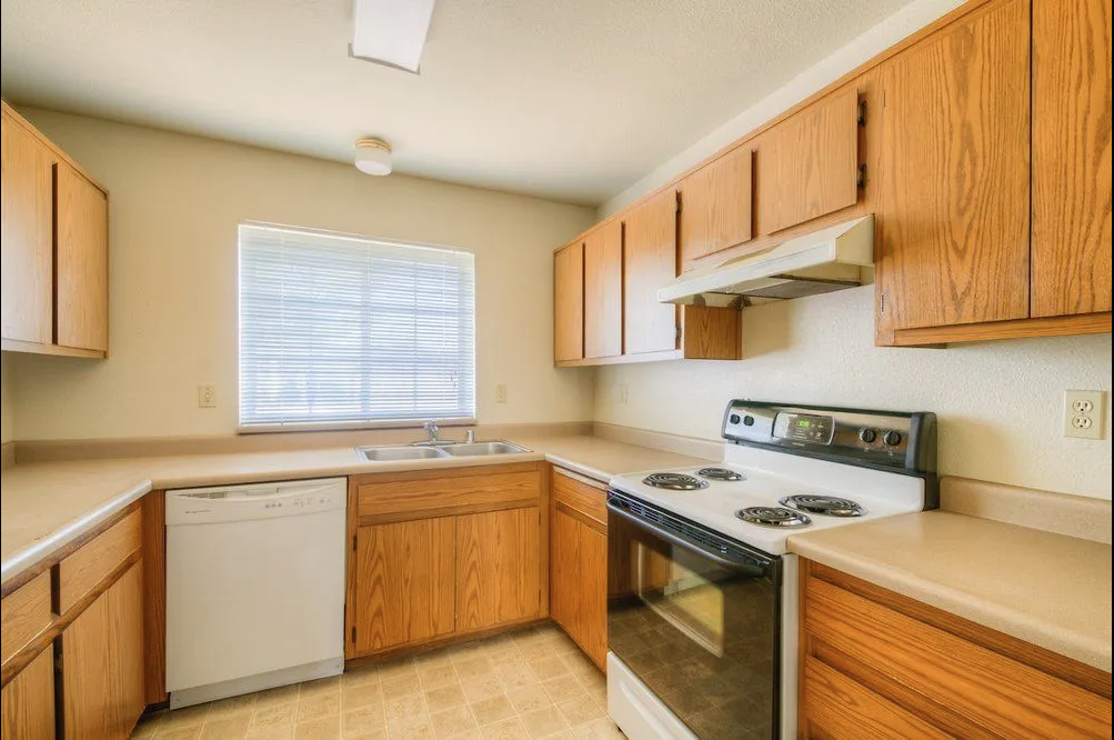 A kitchen with wooden cabinets and white appliances