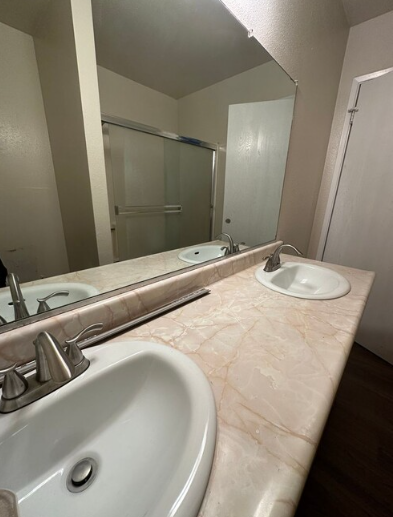 A bathroom with two sinks and a large mirror