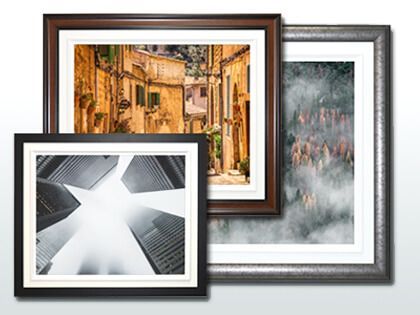 Three framed pictures are sitting on top of each other on a white wall.