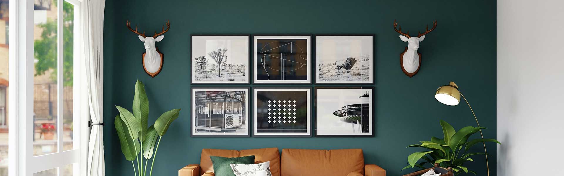 A living room with a brown couch and a green wall, with six framed prints of landscape photos