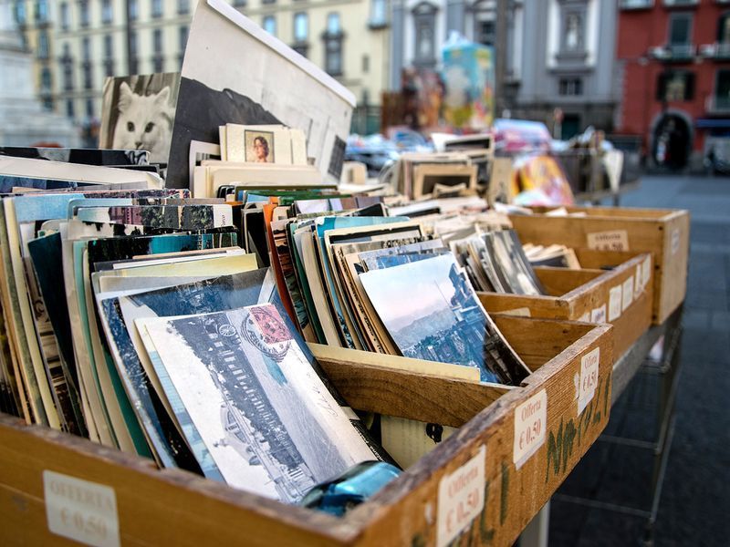 A wooden box filled with books and postcards on a table.