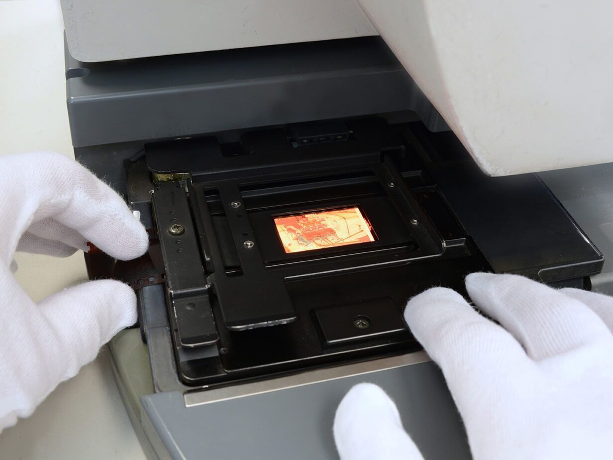 A person wearing white gloves is working on a machine