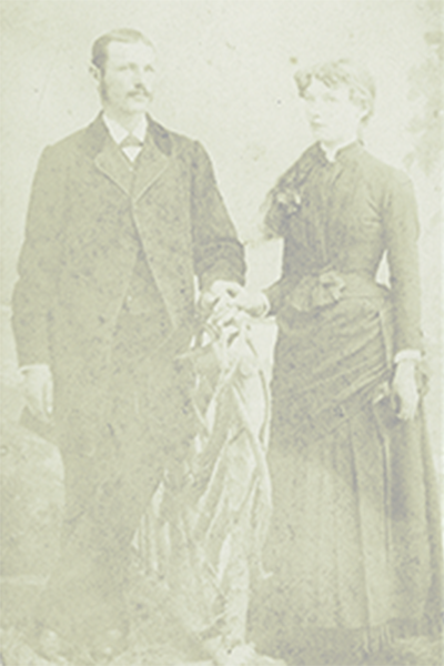 A man and a woman are standing next to each other holding hands in a black and white photo.