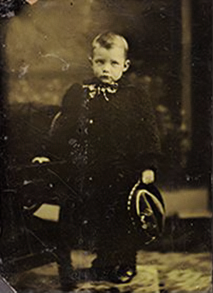 A black and white photo of a young boy in a suit