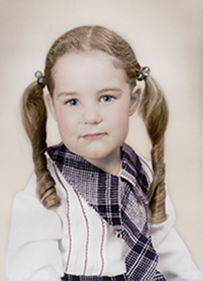 A little girl wearing pigtails and a plaid scarf