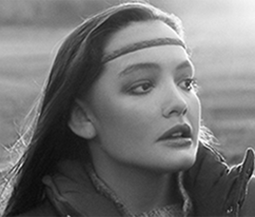 A black and white photo of a woman wearing a headband.