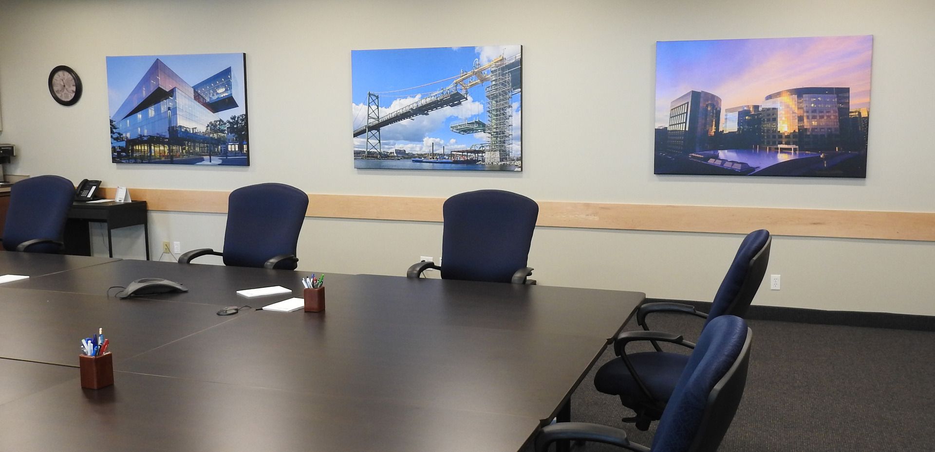 A conference room with a table and chairs and paintings on the wall