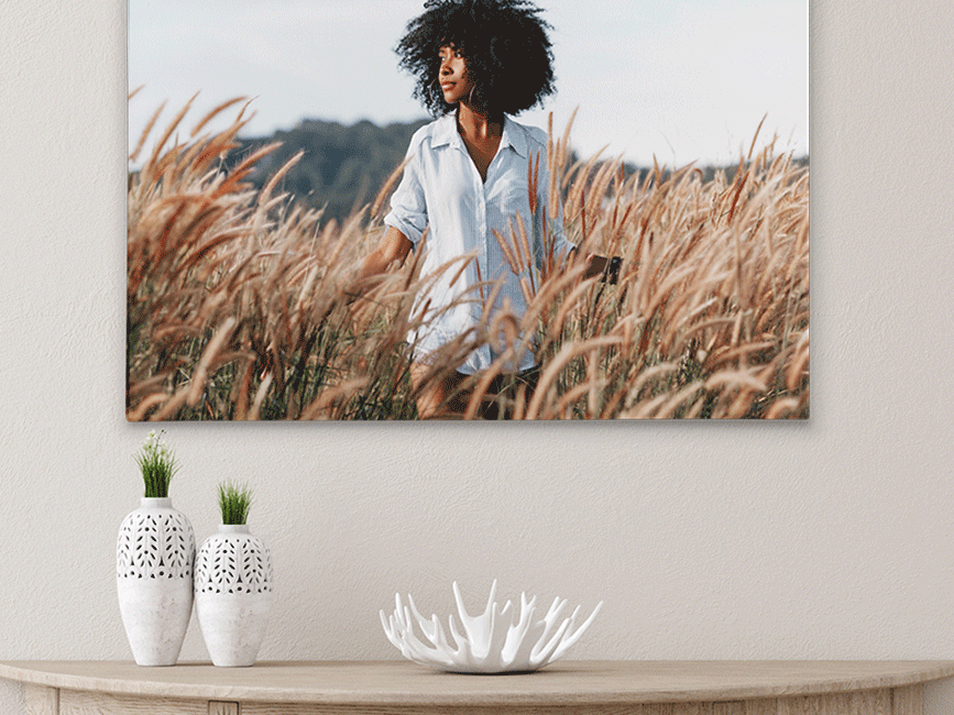 A woman is standing in a field of tall grass.