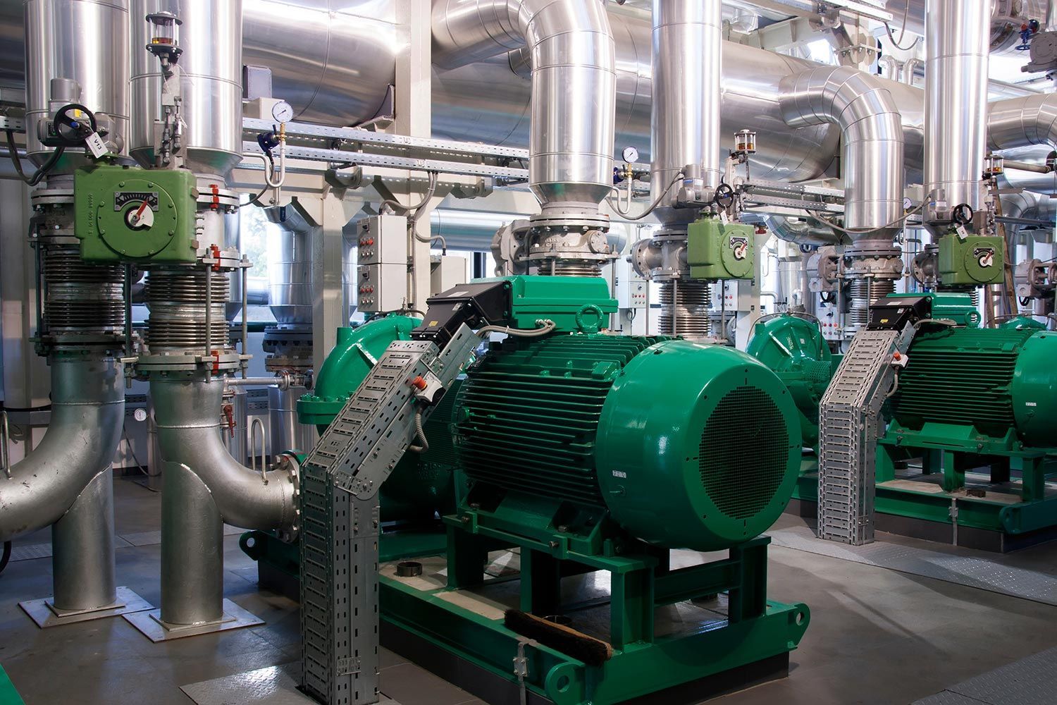 Green industrial pumps and silver pipes