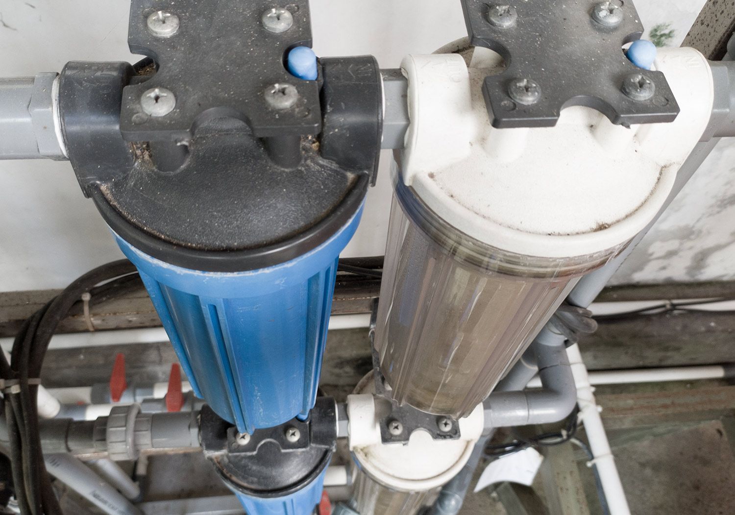 Water filters on metal pipes in a utility room