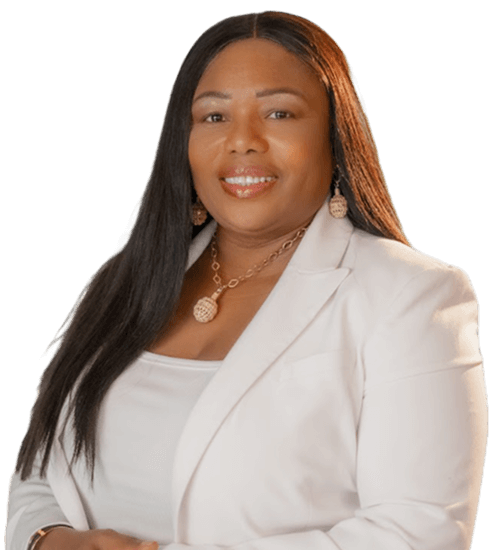 A person with long, dark hair wears a white blazer and a gold necklace, smiling against a plain white background.