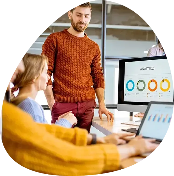 A man is standing in front of a computer screen that says analytics.