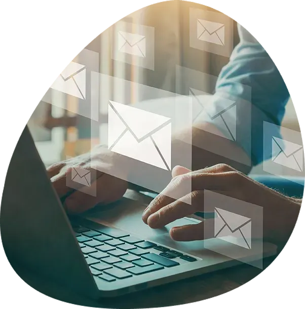 A person is typing on a laptop computer with envelope icons coming out of the screen.