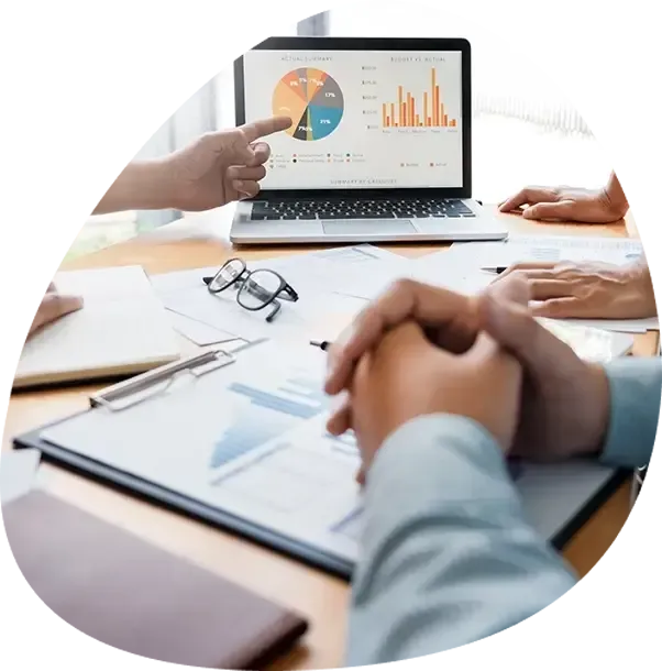 A person is pointing at a graph on a laptop screen