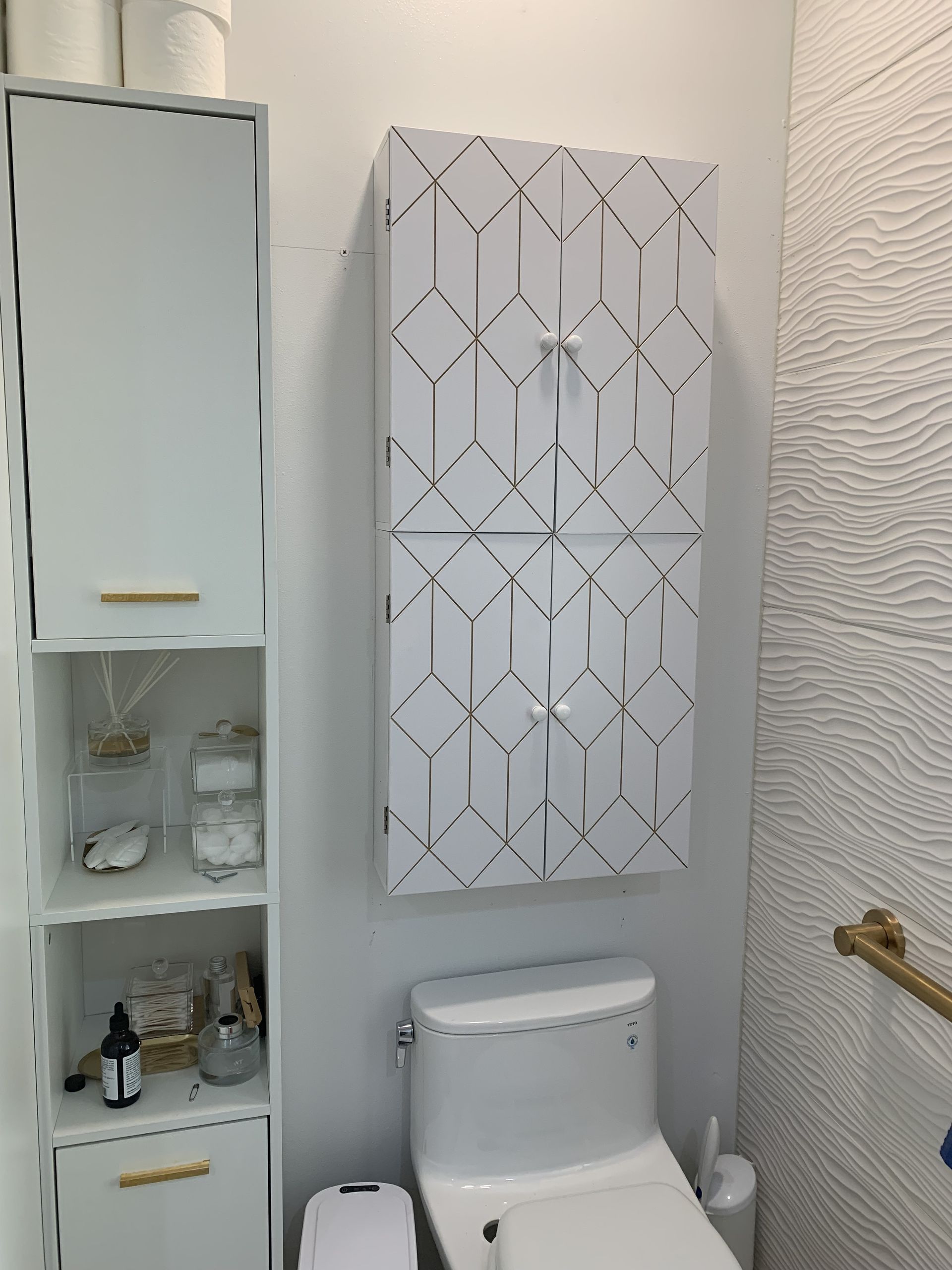 A bathroom with a toilet , shelves , and a cabinet.