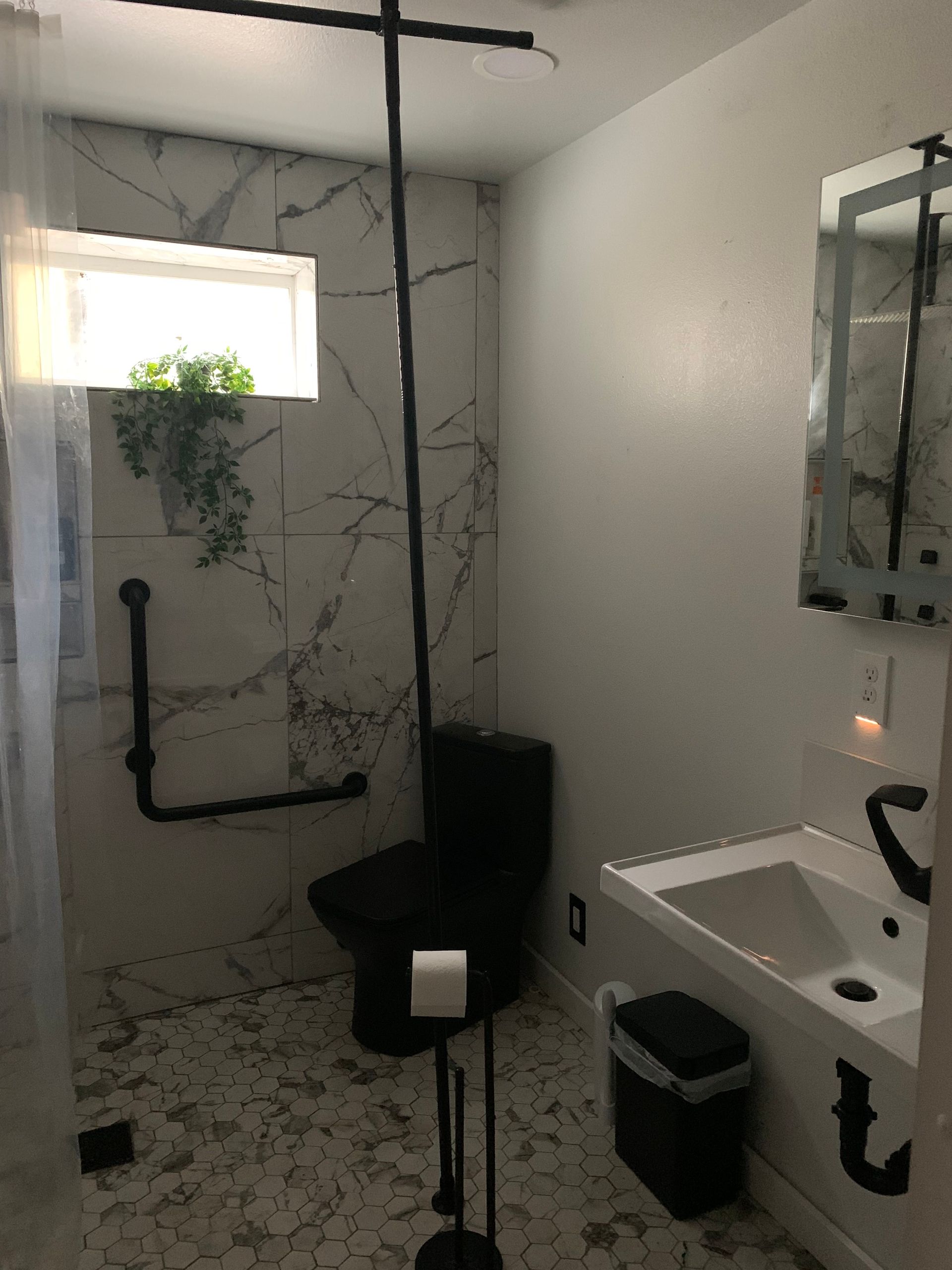 A bathroom with a toilet a sink and a mirror