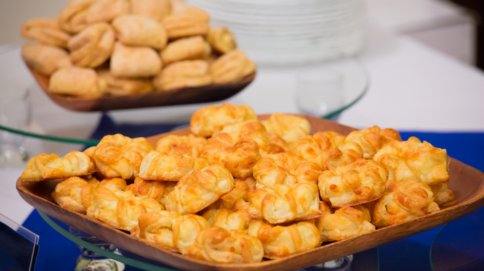 A wooden tray filled with puff pastry on a table.