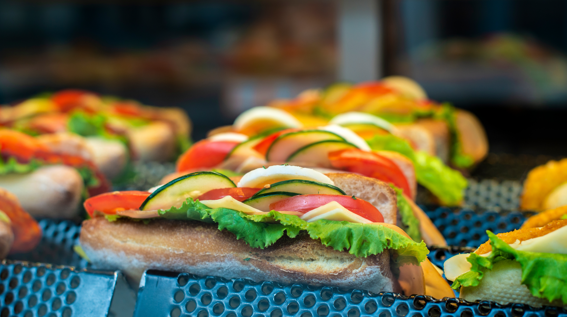 A bunch of sandwiches are sitting on a tray on a table.