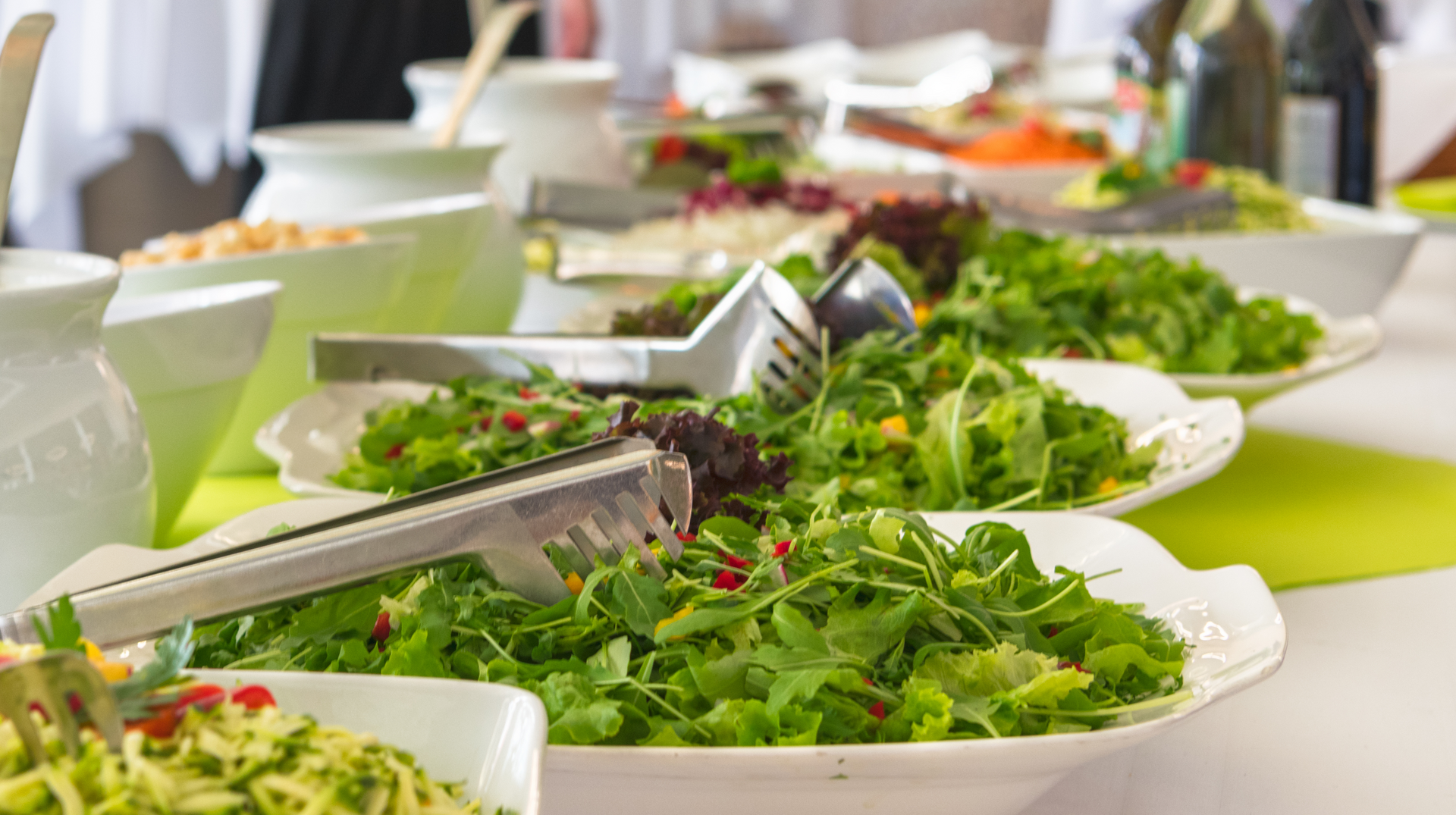 There are many different types of salads on the table.