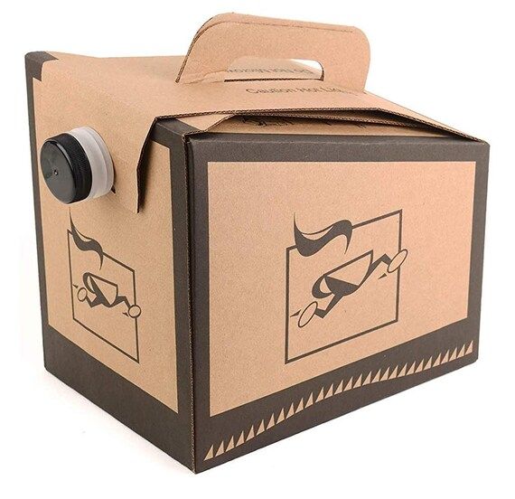 A cardboard box with a handle and a bottle in it