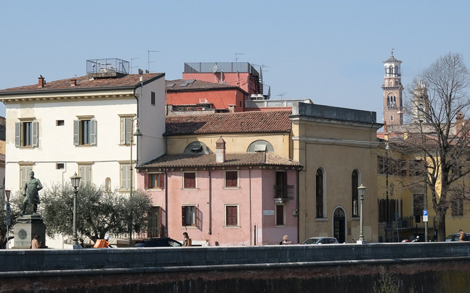 Di fronte a una fila di edifici si trova la statua di un uomo