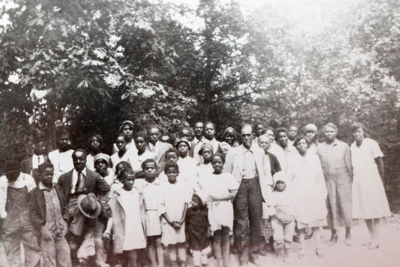 Group of men, women and children - standing on the Log Providence Property with the forest in the background.