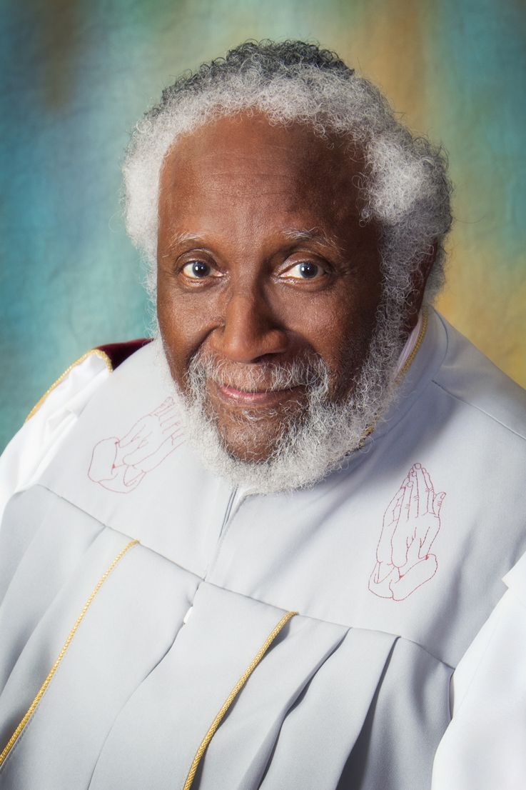 Pastor David P. Ballenger - an African American man with a friendly smile, brignt eyes, and gray hair
