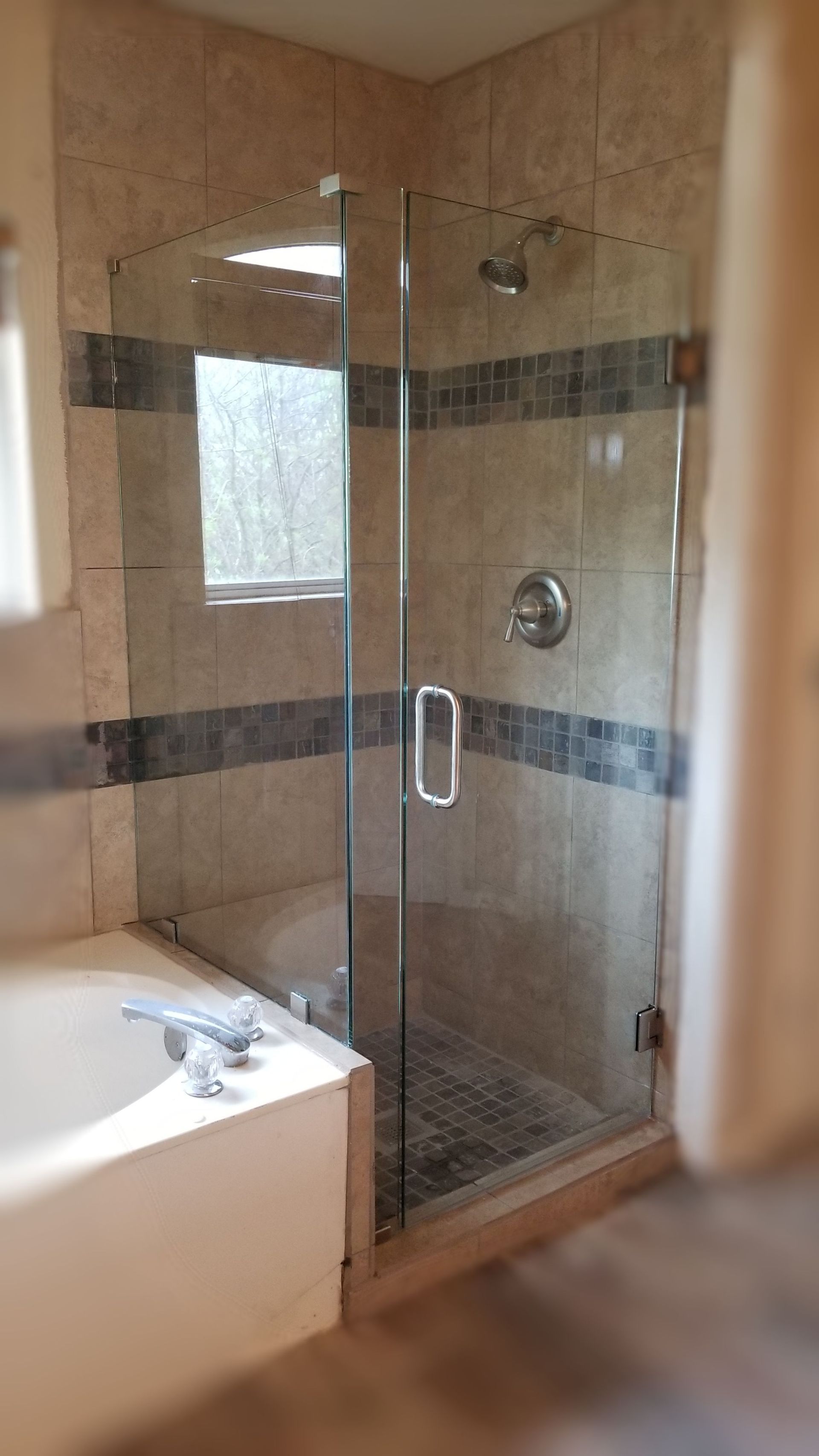 Bathroom with glass shower doors and tiled walls.