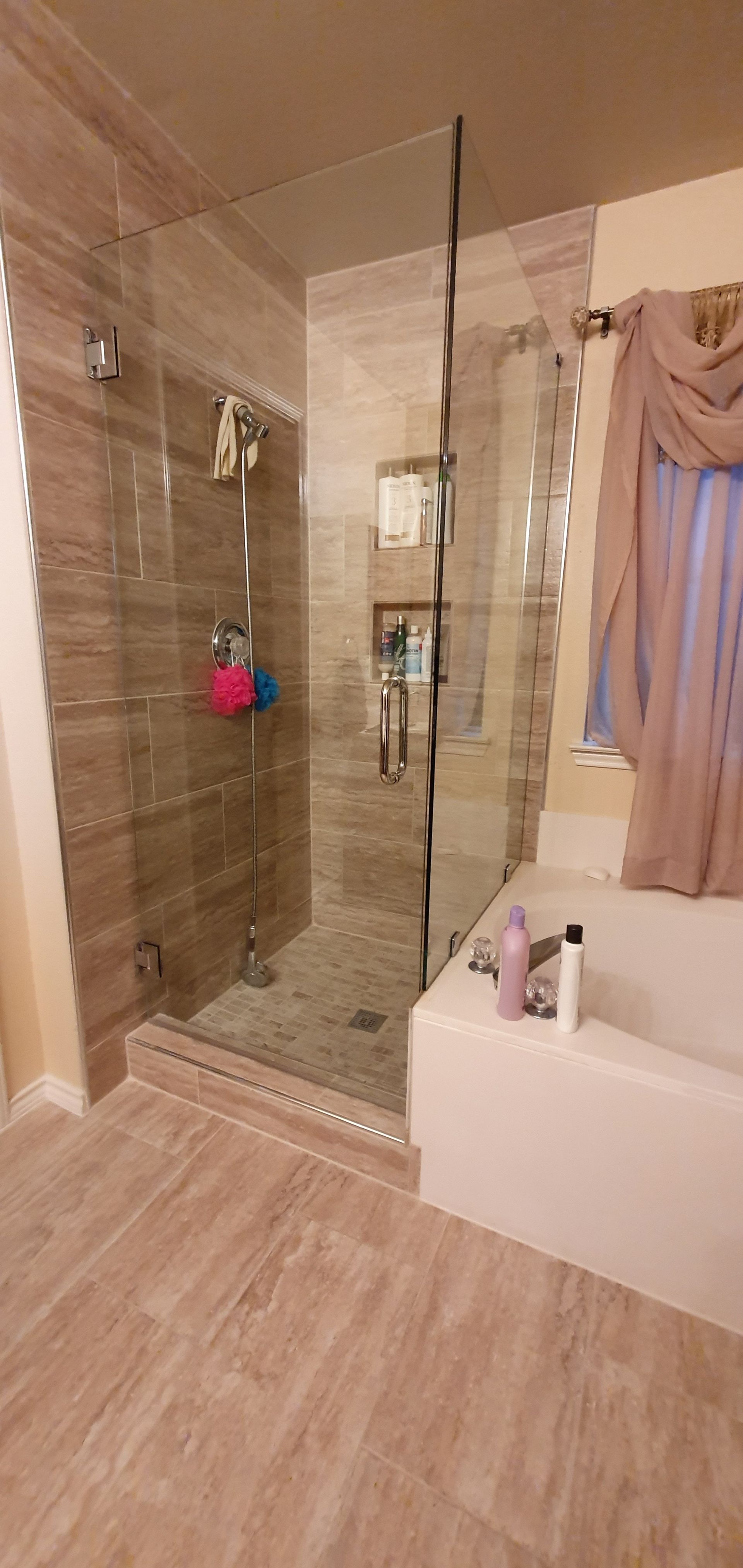 A modern bathroom with a glass shower enclosure and a built-in tub.