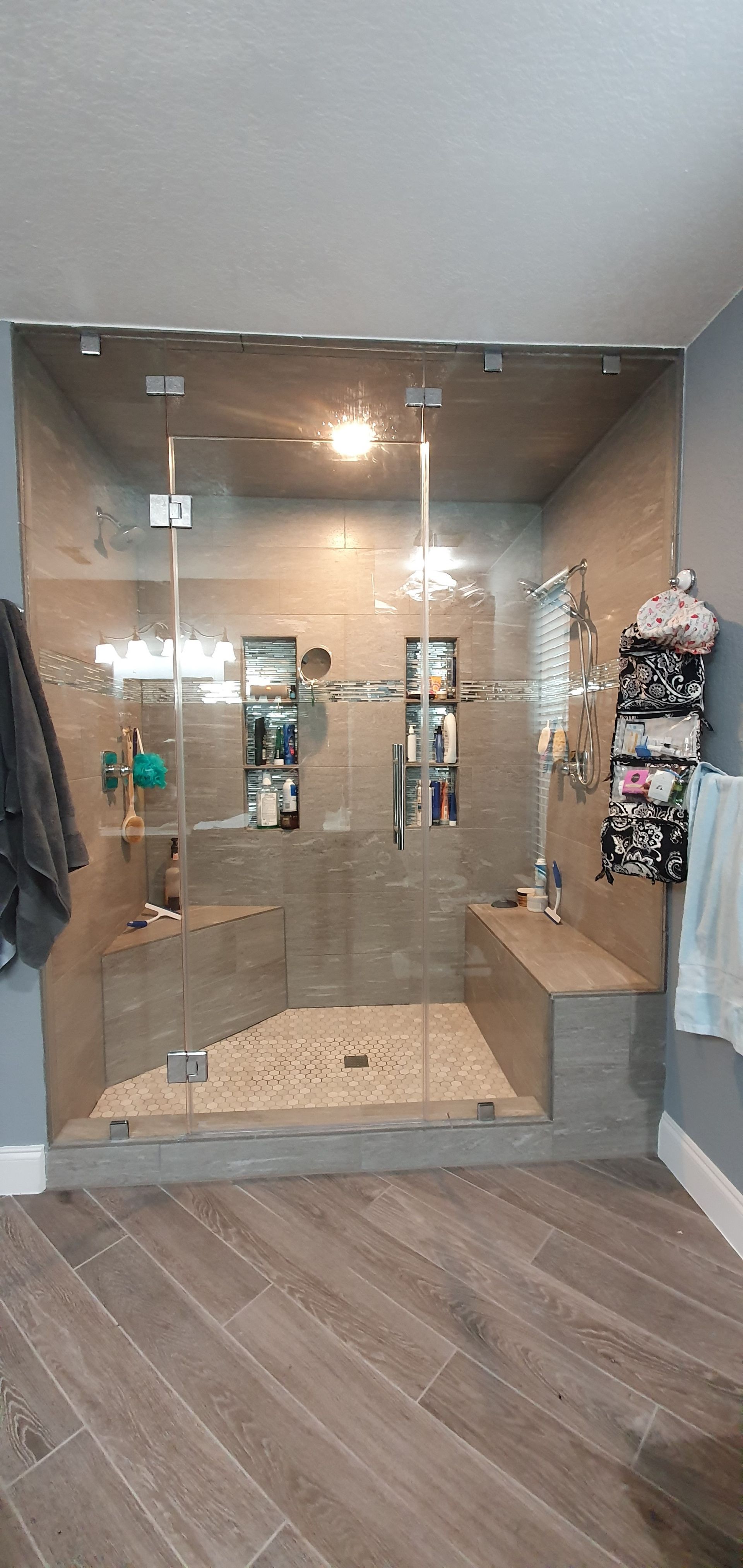 Modern bathroom with a glass shower enclosure and a stone tile floor.