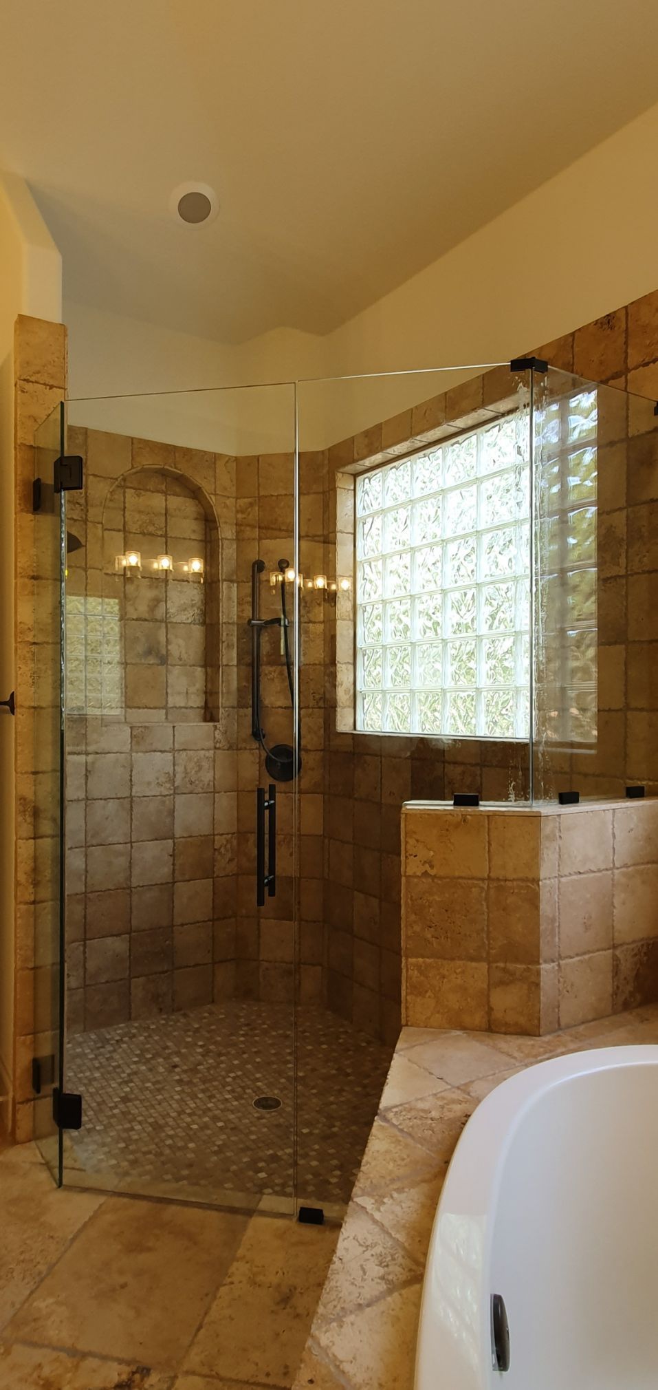 Bathroom with a glass shower enclosure and a window with glass blocks.