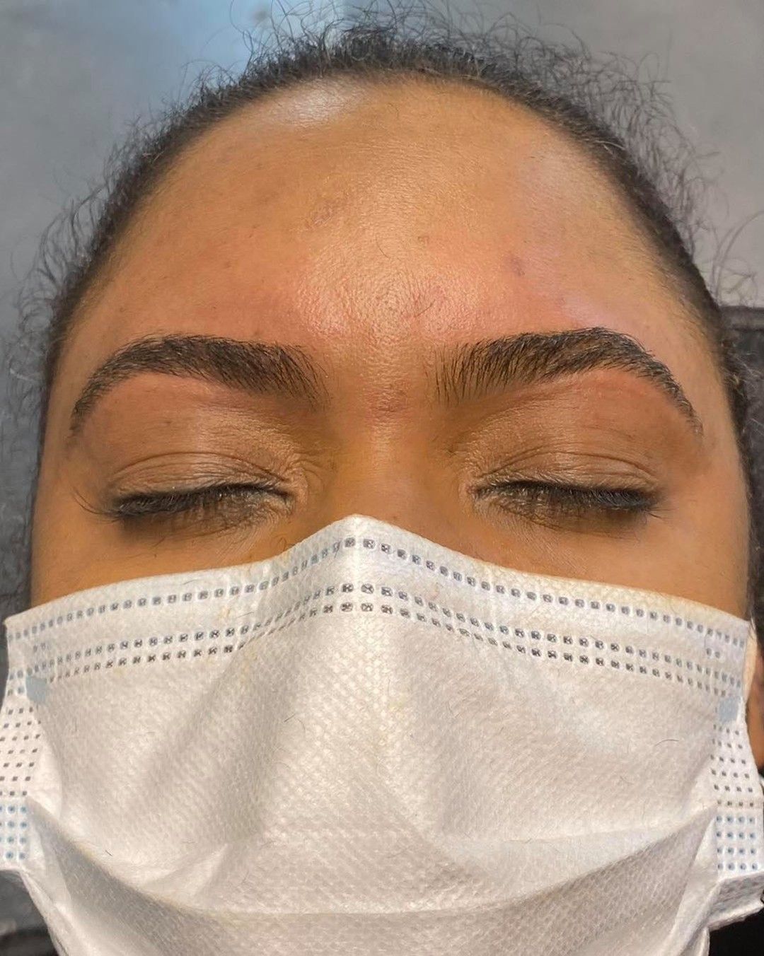 A close up of a woman getting eyelash extensions.